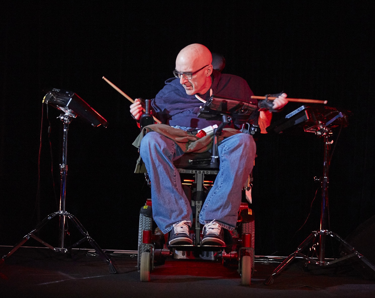 Production Photo from Re-calculating — An actor playing drums in a wheelchair