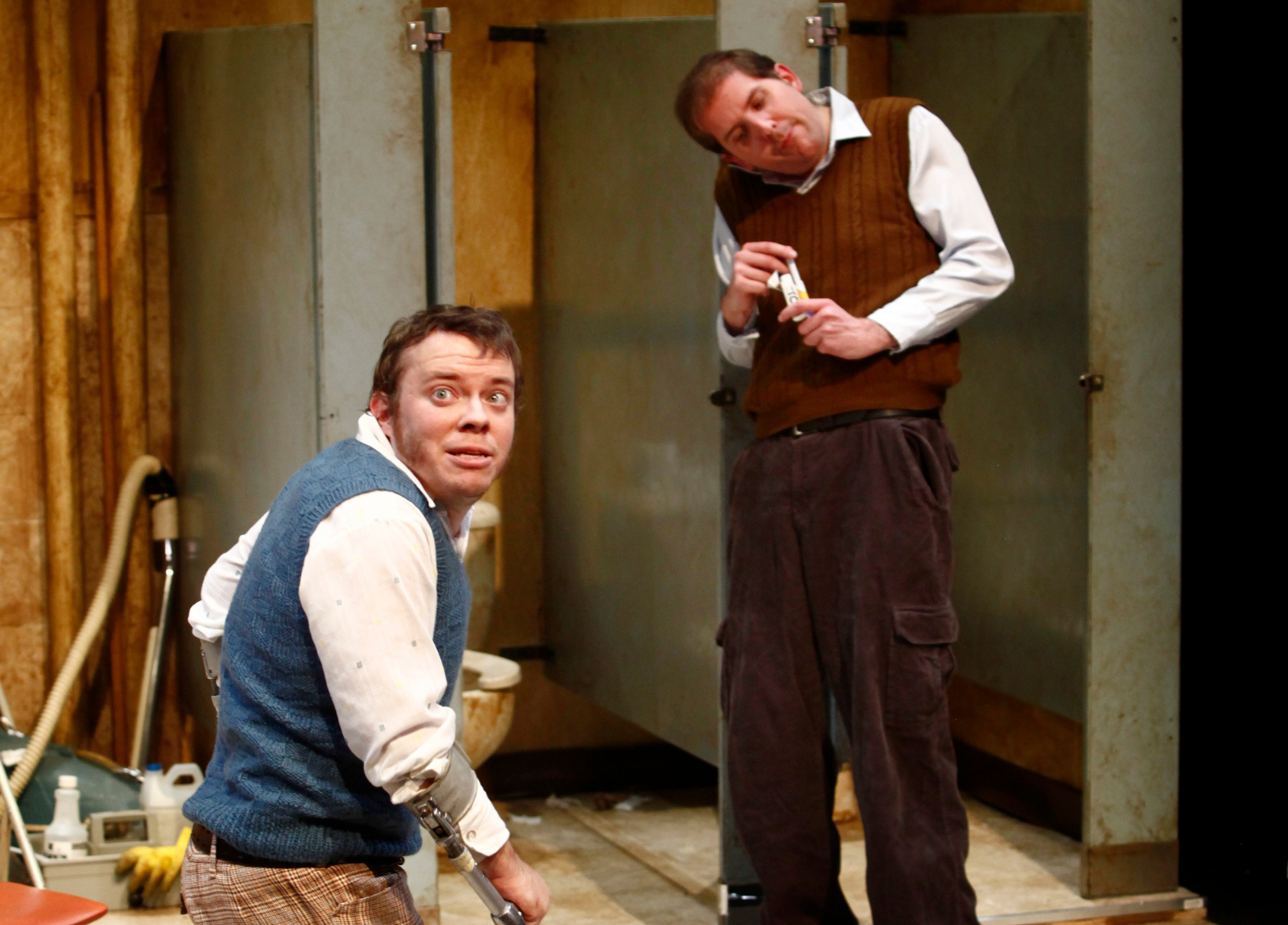 Production Photo from Creeps - Two actors in a bathroom set, one in crutches.