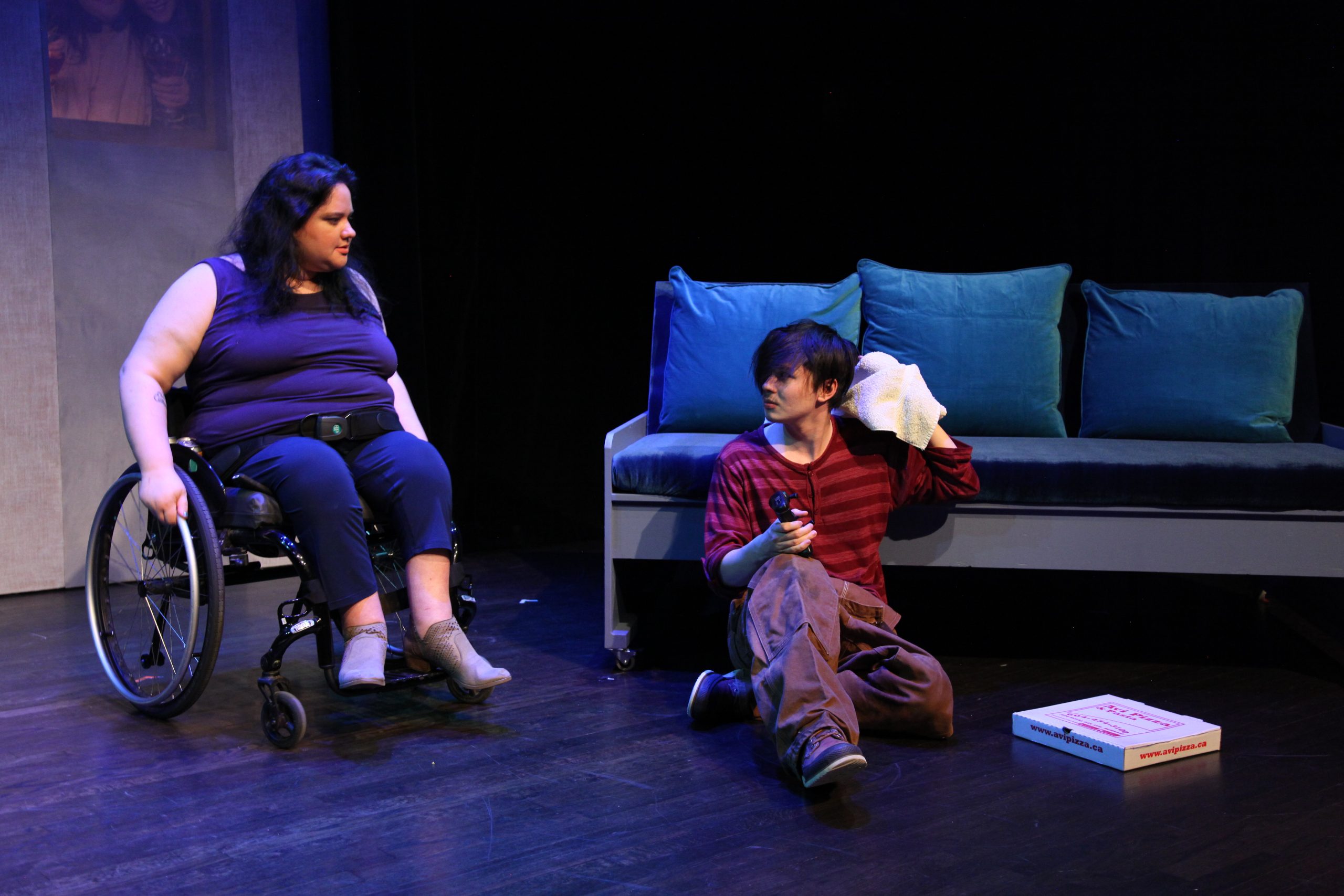 Production Photo from Act of Faith - Two actors looking at each other, one sitting on the ground, the other in a wheelchair.
