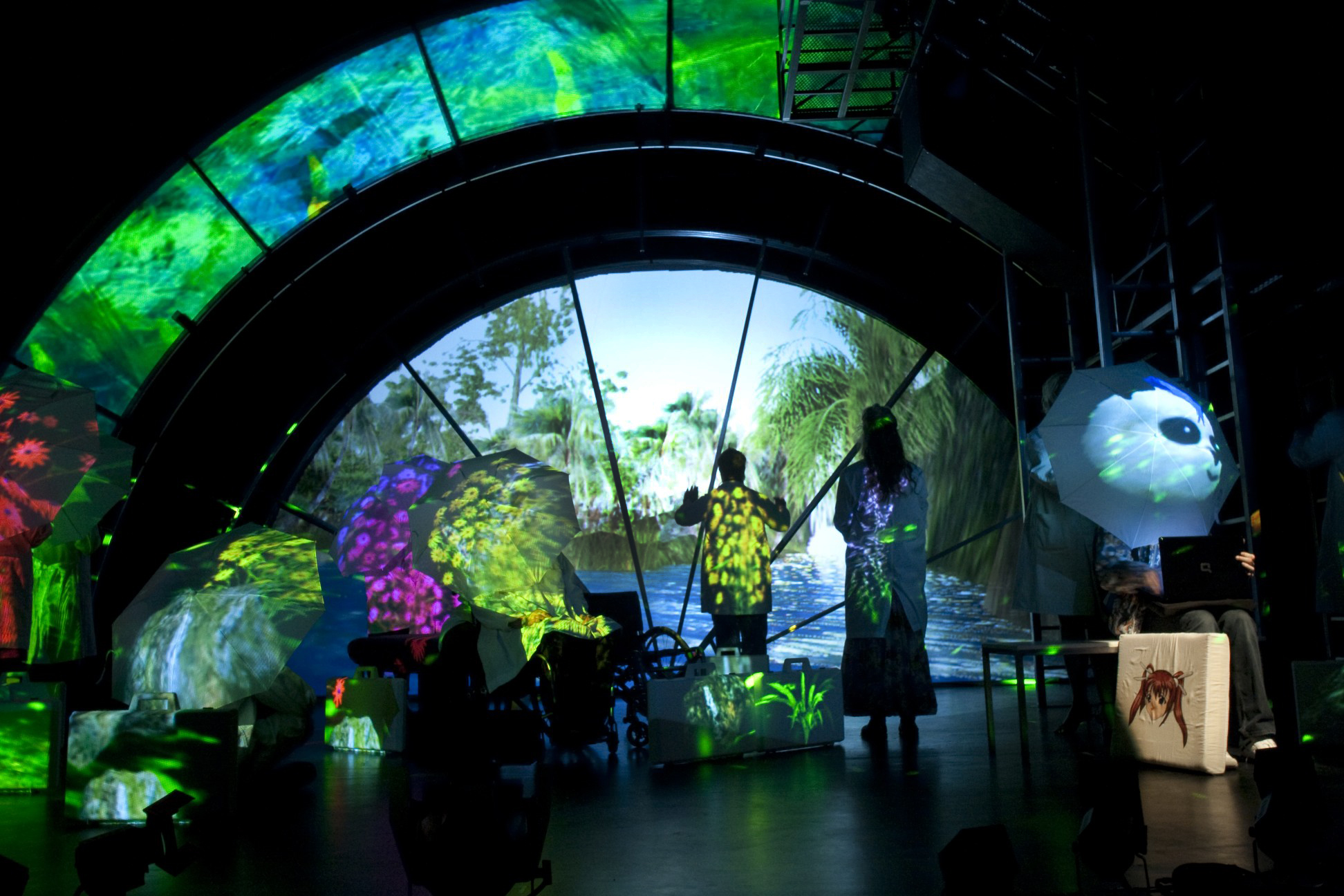 Production Photo from Spine - A spiralled, green, set with actors onstage.