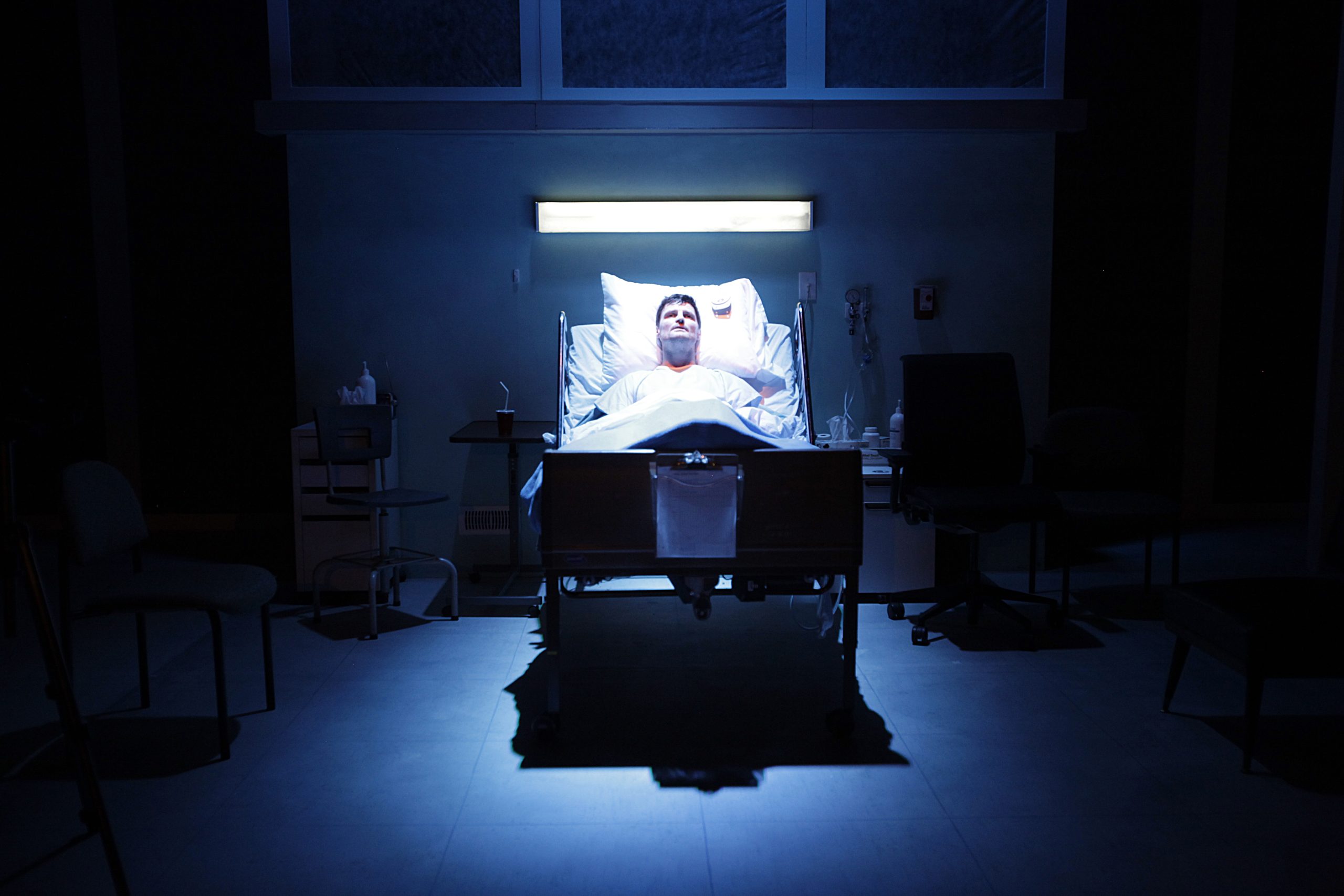 Production Photo from Whose Life is it Anyway? — An actor in a hospital bed.