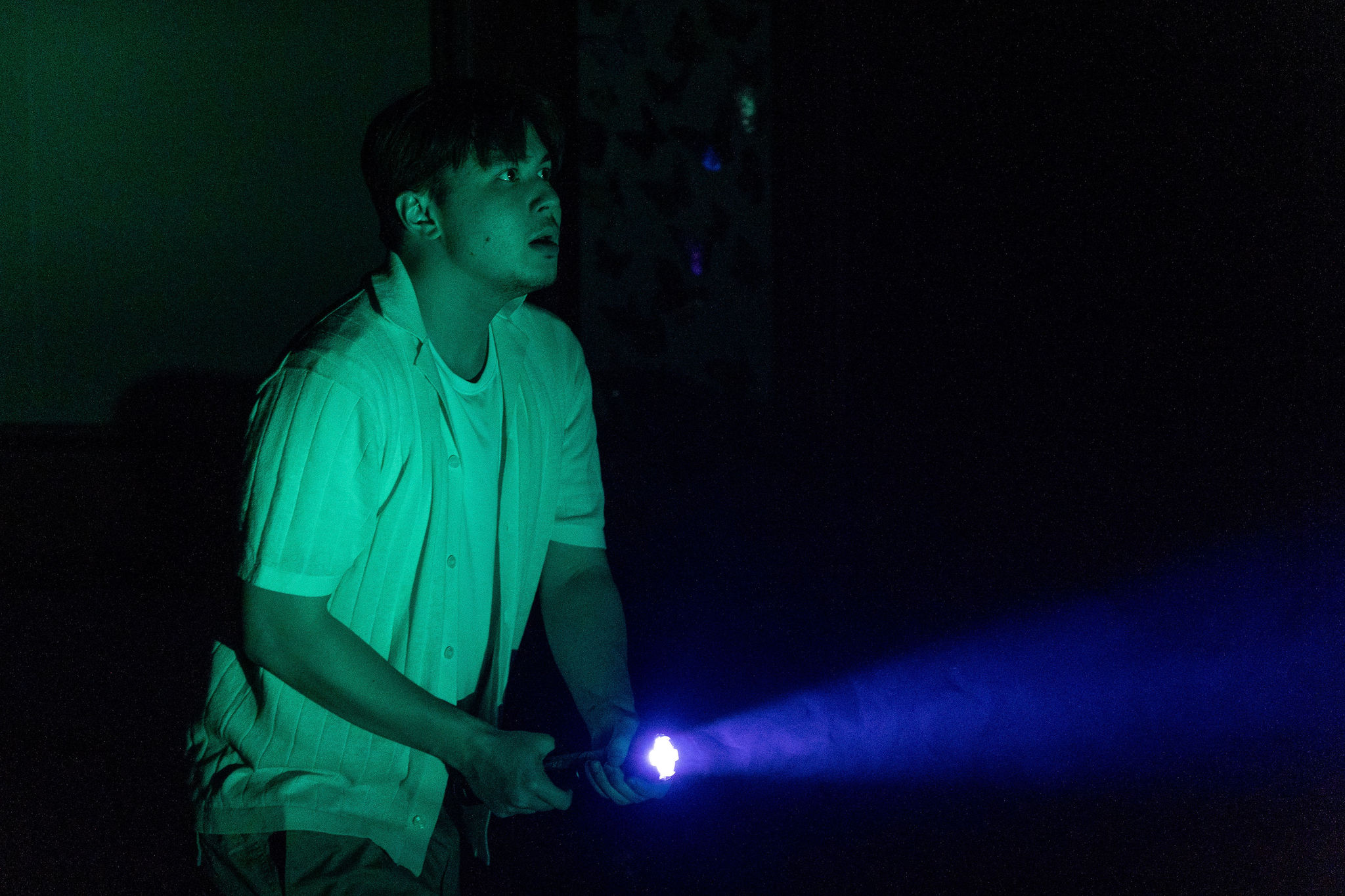 Production Photo of Faye's Room - An actor in the dark with a flashlight